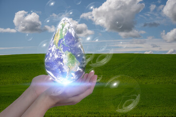 earth day concept saving our planet earth hand holding a water drop with world map inside with...