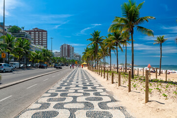 Ipanema beach with mosaic of sidewalk in Rio de Janeiro, Brazil. Ipanema beach is the most famous beach of Rio de Janeiro, Brazil. Cityscape of Rio de Janeiro. - 772232584
