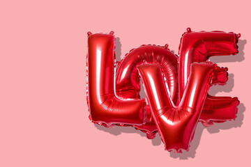 Word love in english alphabet from red balloons on a bright background. Minimal love concept.