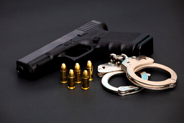Hand gun with ammunition on dark background. 