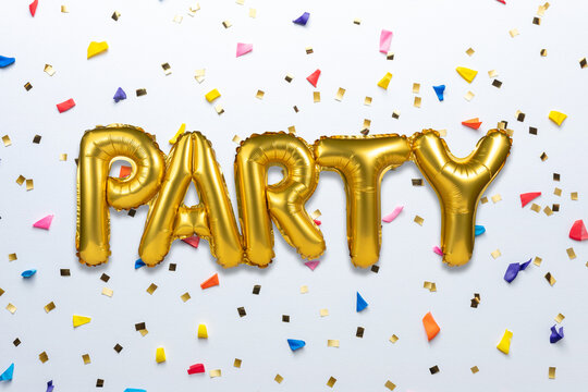 Creative composition made with Party foil balloon and party confetti on white background. Minimal celebration party concept.