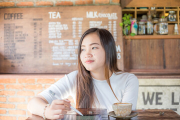 Business asian woman sittingin art cafe use tablet for business communication - 772243981
