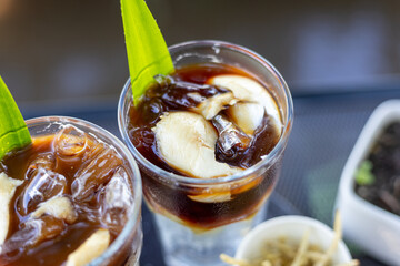 Iced coffee mixed with milk in a clear glass Coffee mixed with coconut water and coconut meat,...