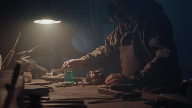 A man builds a bomb in his workshop at night