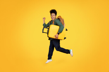 Fototapeta na wymiar Joyful african american man running with luggage