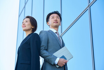 スーツ姿の男女と現代的な建築