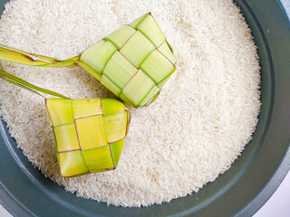 Ketupat on rice. Ketupat is a Javanese rice cake packed inside a diamond-shaped container of woven...