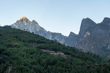 Scenic view of rural houses on slope of a mountain covered with forests