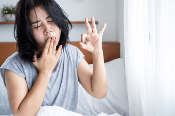 morning fatigue, waking up tired concept with Asian woman doesn't feel refreshed after sleeping