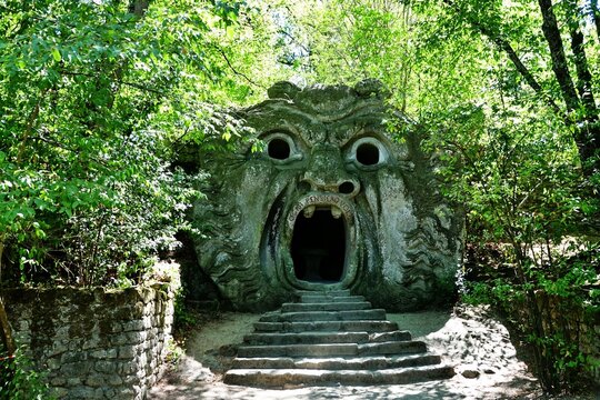 Bomarzo, Viterbo, Lazio, Italy - 08.25.2020: Orcus mouth sculpture at famous Parco dei Mostri (Park of the Monsters), also named Sacro Bosco (Sacred Grove) or Gardens of Bomarzo in Bomarzo