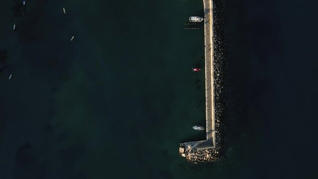 Aerial top view by drone of a harbor of the famous resort Chersonissos on Crete, Greece during sunset.