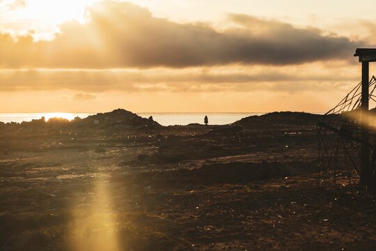 Silhouetted figure standing alone facing the sunrise over sea near Bizerte, Tunisia