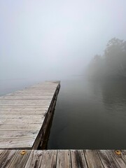Picturesque dock on a tranquil lake surrounded by a foggy atmosphere