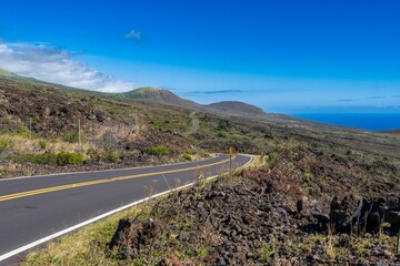 Aerial view of a winding road leading up to the coastline of a tranquil ocean