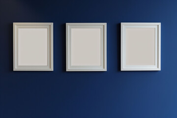 Three pristine white frames are aligned against a rich dark blue wall, creating a striking contrast and a perfect canvas for future artistic expressions