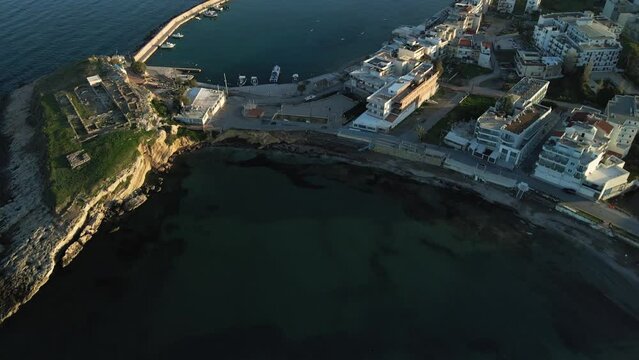 Aerial top view by drone of a harbor of the famous resort Chersonissos on Crete, Greece during sunset.