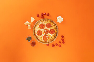 pizza with ingredients on orange background