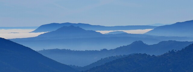 Majestic view of blue mountains shrouded in a wispy mist. - obrazy, fototapety, plakaty