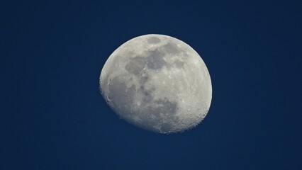 Moon during the Waxing Gibbous phase isolated in the blue sky.