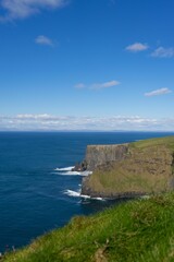 Stunning landscape featuring a rocky shoreline with blue ocean waters. Cliffs of Moher, Ireland.