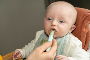 bébé mangeant un petit pot à la cuillère
