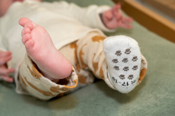 pied d'un bébé de quelques mois avec une chaussette manquante