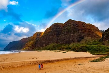 Scenic view of a rainbow over the sandy beach in spring in Kauai, Hawaii, Pacific Island