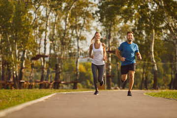 Happy couple engages in a refreshing jog in the city park. Runners smiles reflect the shared...