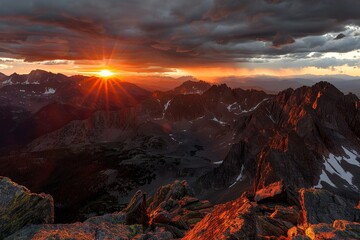 Naklejka premium Fiery Sky: Majestic Sunset Over Rugged Mountains