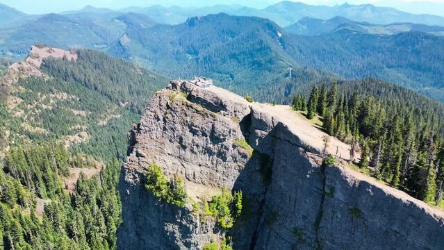 Aerial video of the peak on the rocky mountain covered with fir trees in the forest