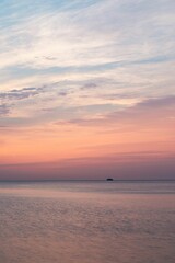 Vertical shot of a boat sailing in Lake Michigan at sunset