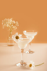 Healthy organic homemade fresh lemonade or cocktail. Nonalcoholic mocktail decorating with flower camomile. Natural beige background.