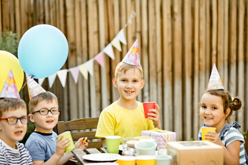 Cute funny nine year old boy celebrating his birthday with family or friends with homemade baked...