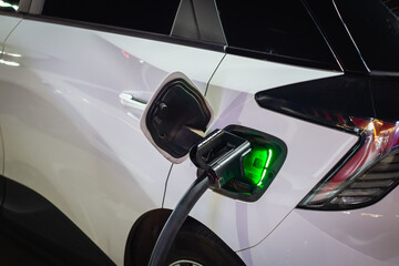 Electric cars parked at charging stations at night have status lights. It uses clean energy that is environmentally friendly and is becoming very popular nowadays.