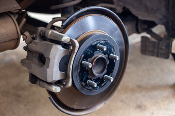 The car's wheels were removed, exposing the discs and disc brakes for tire changes and repairs.