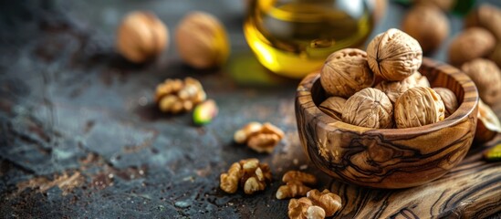 A wooden bowl filled with assorted nuts sits next to a bottle of oil on a table. - obrazy, fototapety, plakaty