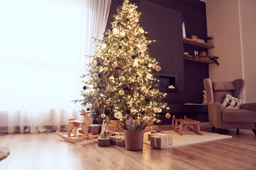 Christmas decor in domestic, cosy living room with christmas tree with lighting strings, balls,...