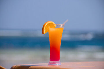 glass of orange juice on the beach