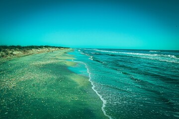 Stunning aerial view of a beach in summertime, with a bright blue ocean