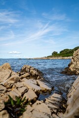 Fototapeta na wymiar Vertical shot of a beautiful sunny rocky shoreline in Croatia