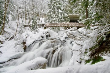 Landscape of the Deception Falls with long exposure covered in the snow in Stevens Pass
