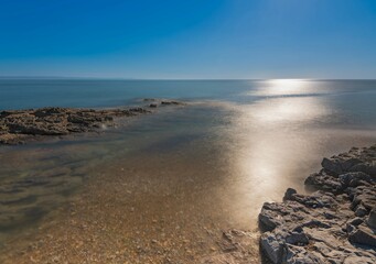 Peaceful scene on the rocky shore and the tranquil ocean.