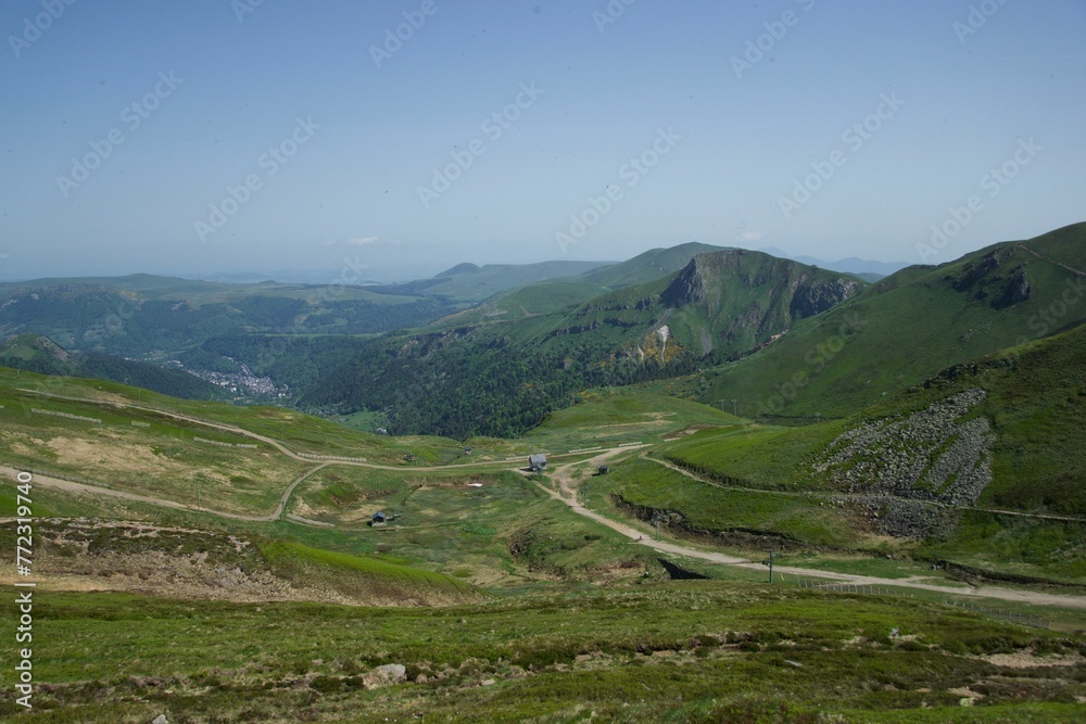 Wall mural Scenic landscape of a winding green valley surrounded by majestic mountains