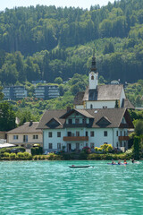 Fototapeta premium Stunning aerial view of a beautiful house, by a lake and forests in the Carinthia region of Austria