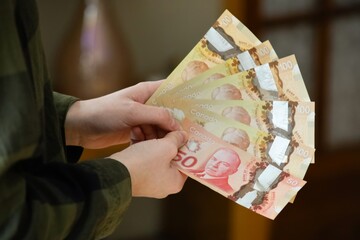 Canadian dollar bills in hands. Concept of money, banking, finance, savings