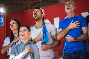 Football / soccer fans singing anthem at the stadium - obrazy, fototapety, plakaty