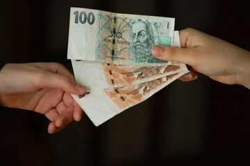 Passing Czech crowns from hand to hand. Concept of money, banking, finance, savings.