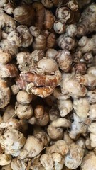Close up pile of tasty fresh aromatic ginger sold at the market as a background.	