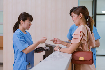 Woman is paying on the reception desk in beauty treatment clinic using contactless credit card.