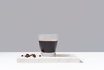 Vaso de café negro sobre mármol y fondo gris 